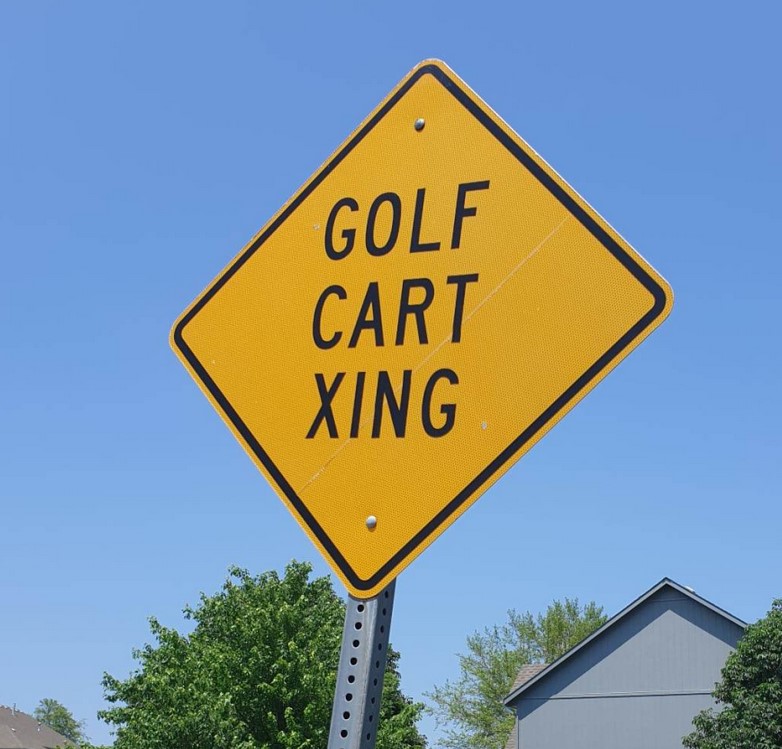 A sign that says "Golf Cart Xing"